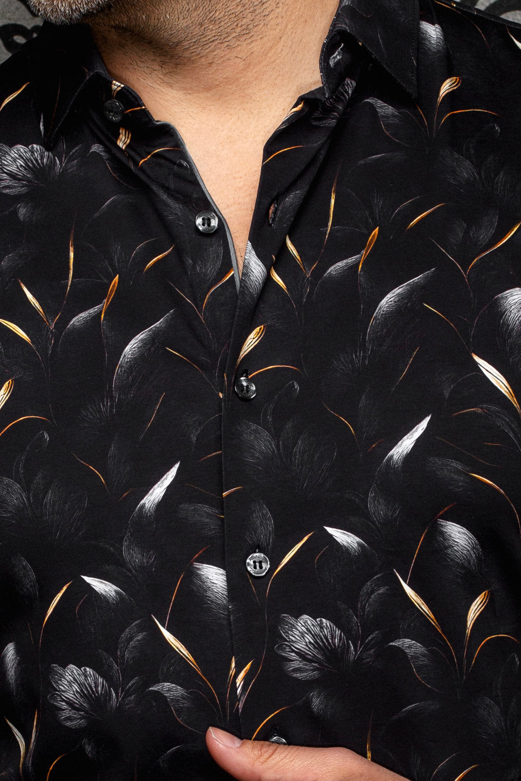 Col, de la patte boutonnée et motif feuilles orange et blanches de la chemise noire pour homme par Au Noir, en gros plan