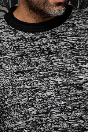 Gros plan de la chandail en cachemire en tricot gris chiné pour homme par Au Noir : le col rond côtelé noir et la maille