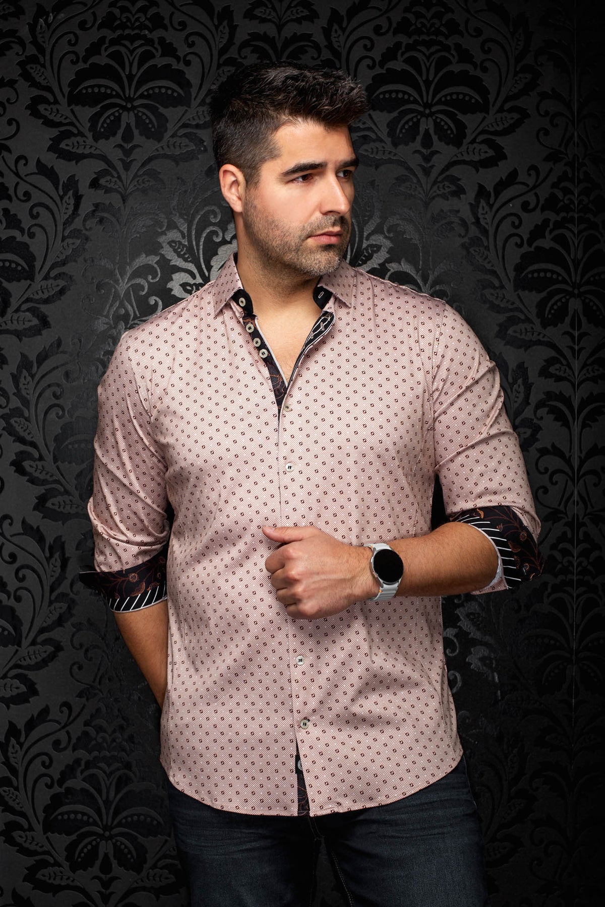 Men's angled front view of a pink geometric-print button-up shirt with rolled black contrast cuffs by Au Noir
