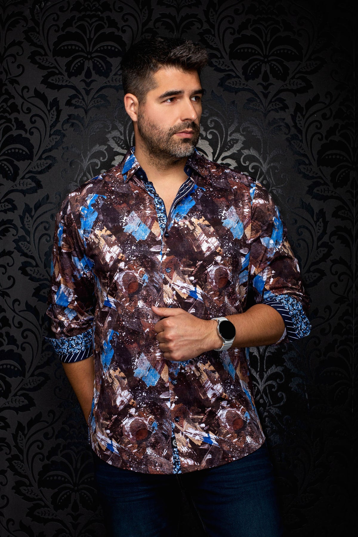 Men's brown abstract print button-up shirt on model, with blue accents and rolled contrast cuffs, front view by Au Noir
