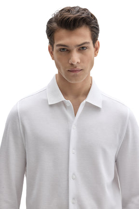 Close-up of men's white textured knit long-sleeve shirt with tonal front buttons and ribbed collar by Robert Barakett