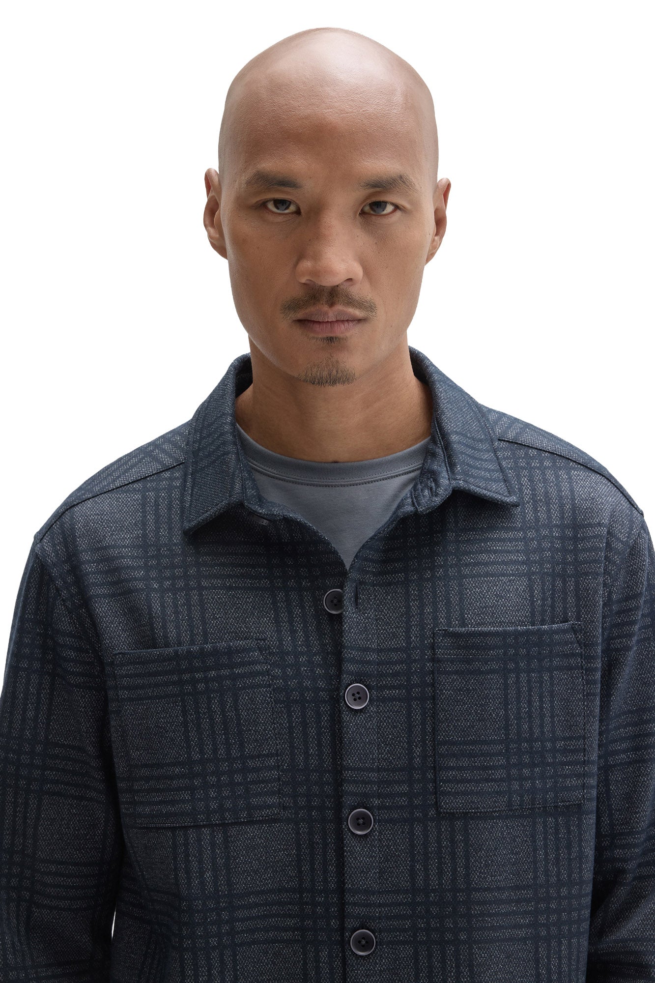 Close-up of men's dark blue plaid overshirt with chest pockets, dark buttons and point collar by Robert Barakett