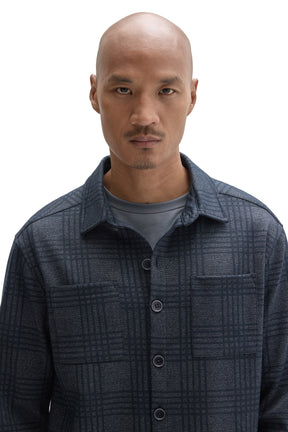 Close-up of men's dark blue plaid overshirt with chest pockets, dark buttons and point collar by Robert Barakett