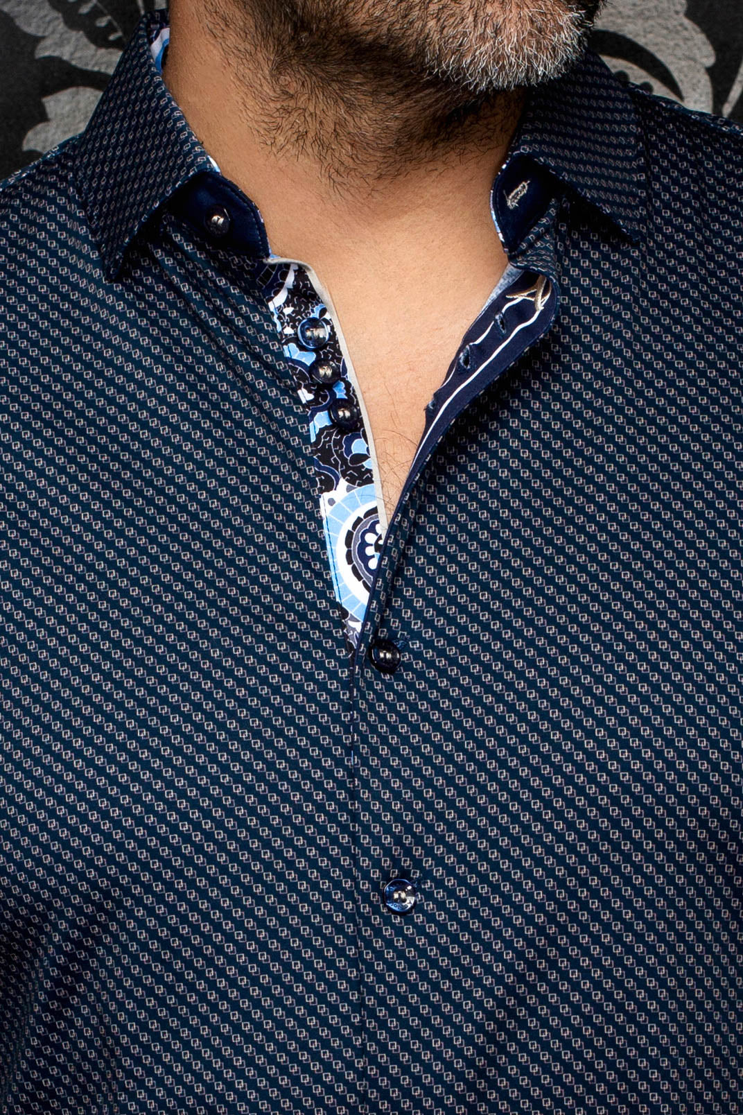 Gros plan du col, des boutons et de la patte fleurie contrastée d’une chemise bleu marine pour homme par Au Noir