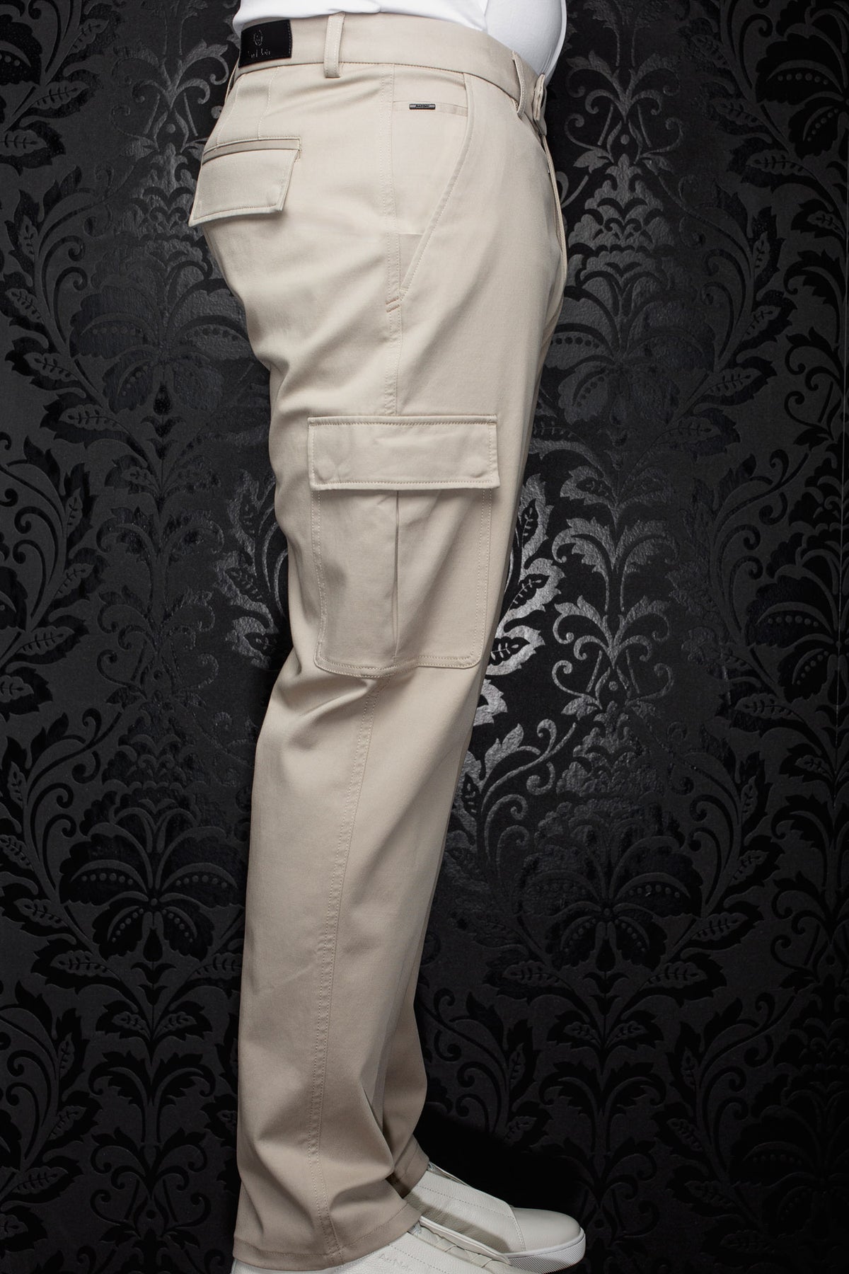 Au Noir men's beige cargo pants shown from the side, with flap pockets, belt loops, and straight legs