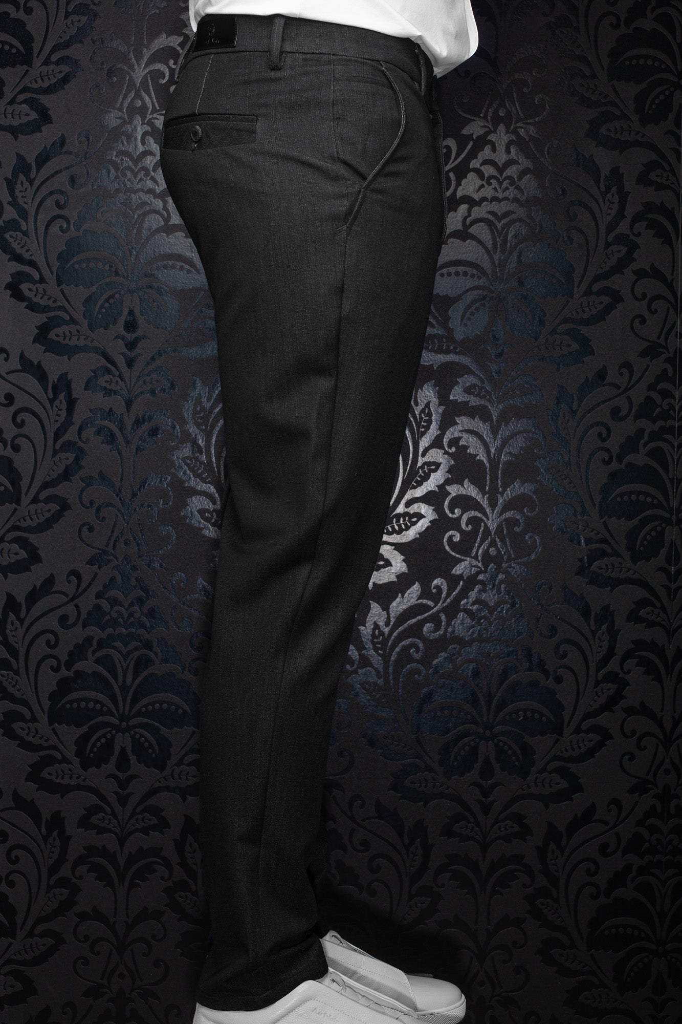 Pantalon noir avec passants, poche passepoilée arrière et couture courbée pour homme par Au Noir, vue de côté