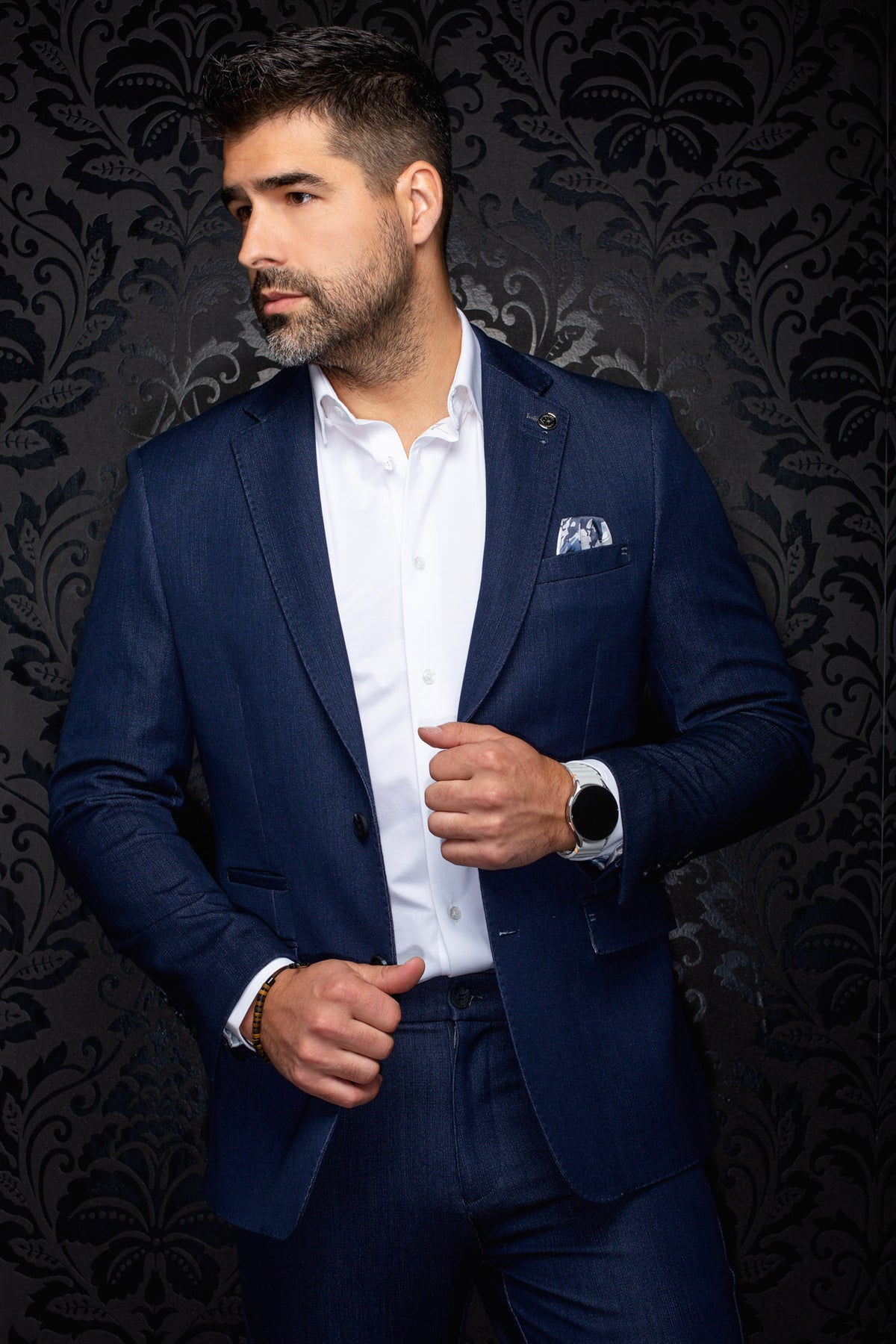 Men's navy blazer on a model, front angled view with notch lapels, pocket square, and flap pockets by Au Noir
