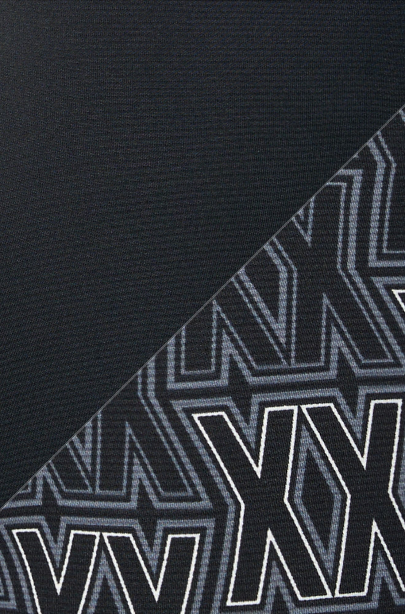 Gros plan sur le tissu noir uni et le motif XX gris et blanc sur le sous-vêtement long pour homme par Saxx
