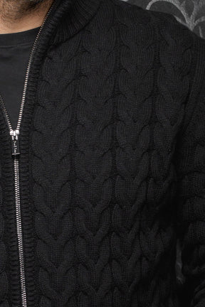 Au Noir men's black cable-knit zip merino jacket showing silver-tone zipper and raised knit pattern, close-up