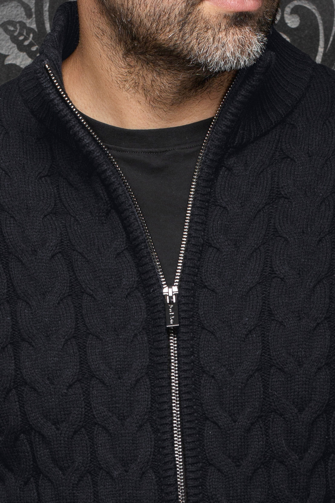 Veste en mérinos noire en tricot câblé avec col côtelé et fermeture argentée pour homme par Au Noir, en gros plan