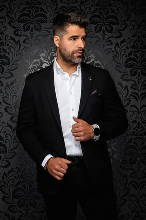 Veston noir à revers crantés avec poche poitrine et petite épinglette pour homme par Au Noir, vue de face